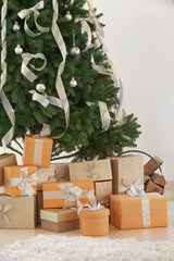 Christmas gifts under fir tree in room
