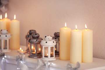 Beautiful Christmas decorations and candles on mantelpiece at home