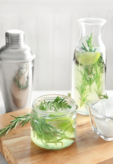 Jar with fresh rosemary drink on wooden board