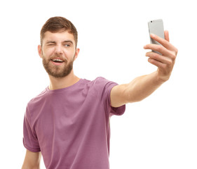 Young man taking selfie against white background