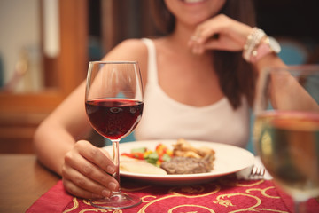 Obraz na płótnie Canvas Woman drinking red wine in restaurant