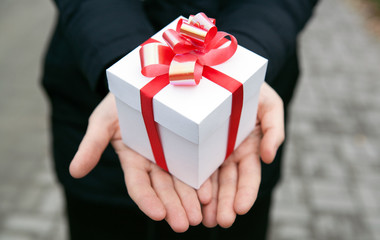 Female hands give you a gift box