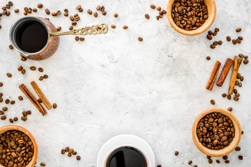 Ingredients for coffee. Roasted coffee beans and cinnamon on grey background top view copyspace