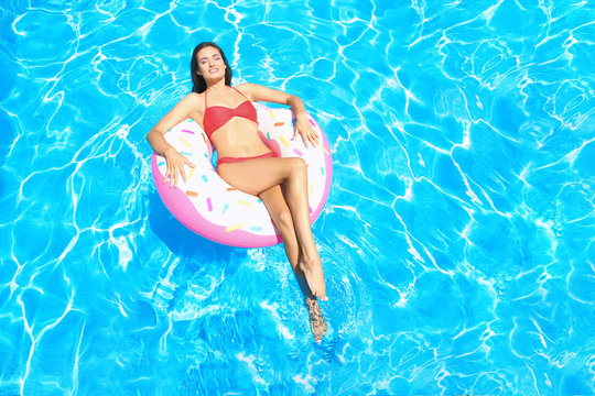 Young beautiful woman sunbathing on   inflatable ring in swimming pool