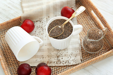 Chia seeds in cup and jug on wicker tray