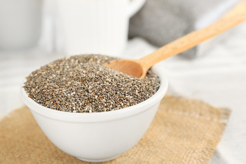 Chia seeds in bowl with spoon on table