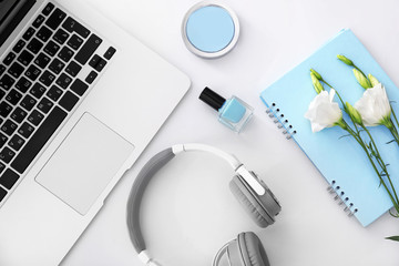 Composition with laptop, headphones, cosmetics and flowers on white background. Beauty blogger concept