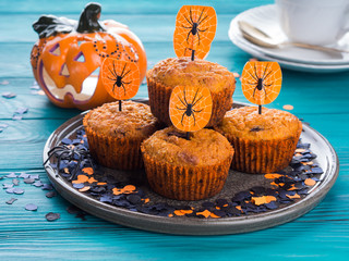 Pumpkin muffins with chocolate chips for Halloween kids party. Holiday decorations