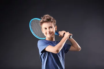Foto op Canvas Cute little boy with tennis racket on dark background © Africa Studio