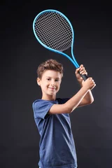 Keuken spatwand met foto Cute little boy with tennis racket on dark background © Africa Studio