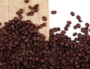 Pile coffee beans on jute, linen sack isolated on white background, top view

