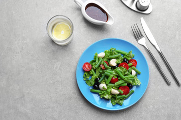 Plate of salad with green beans on table