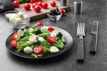 Plate of salad with green beans on table