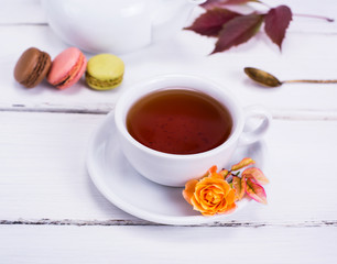 a round white cup with black tea on a white wooden table