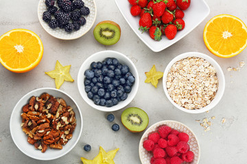 Composition with nutritious oatmeal and different ingredients for breakfast on light background