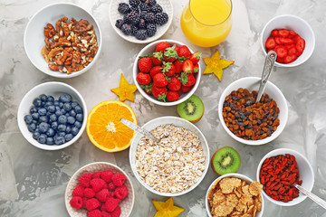 Composition with nutritious oatmeal and different ingredients for breakfast on light background