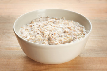 Tasty oatmeal in bowl for breakfast on table