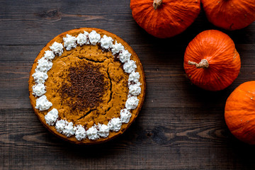 Pumpkin pie for thanksgiving day on dark wooden background top view