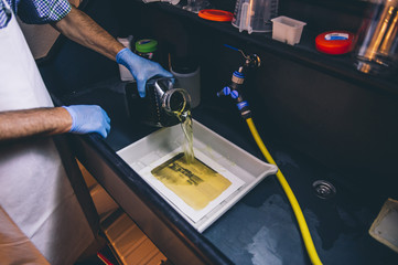 Man works on film black and white platinum print in laboratory.