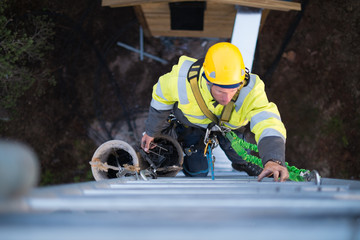 Working at heights, technician climbs up on a communications tower