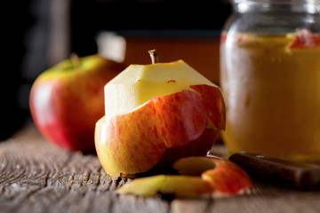 Peeled apple and cider in a jar