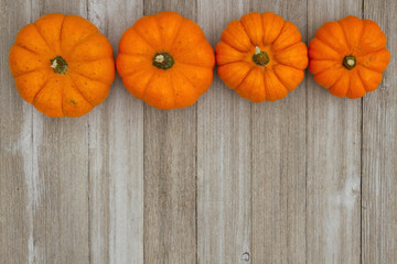 Autumn background with pumpkins on weathered wood