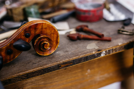 Violin scroll and pegs on a workbench