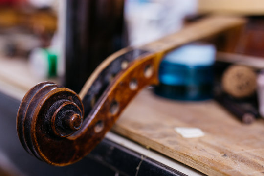 Violin scroll being repaired in a luthier shop