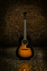 Fototapeta na wymiar Acoustic guitar in retro environment with stonewall and wooden floor