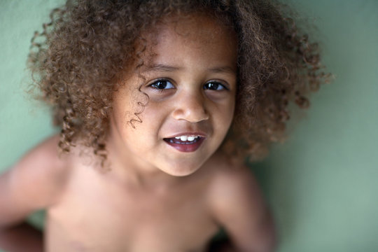 Portrait against green wall of African American Girl