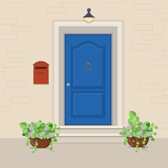 Blue front door with a mailbox on the wall and flowers in the pots