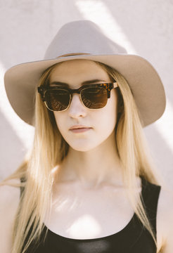 real young woman with vintage sunglasses and grey hat