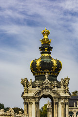 Fototapeta na wymiar Gold ornaments on tower dome of monument building under blue sky.
