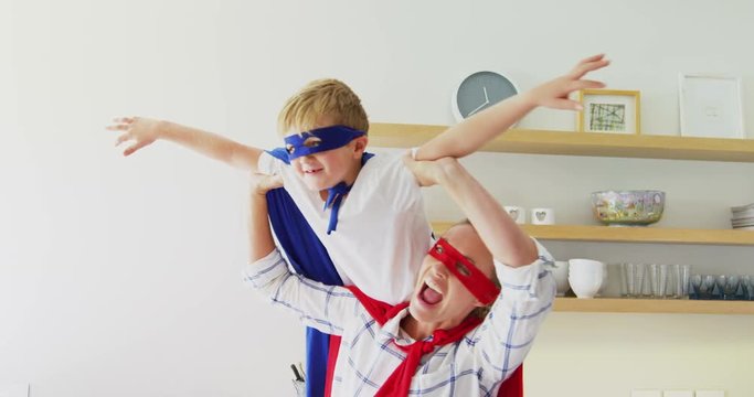 Mother and son pretending to be superhero in living room 