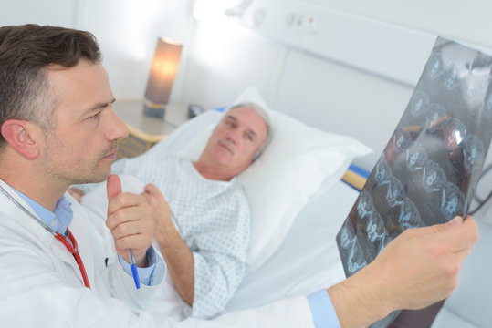 mature doctor examinating patients xray at the hospital