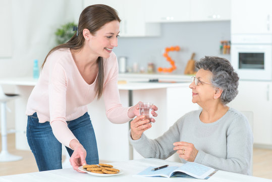 woman serving the old woman with water