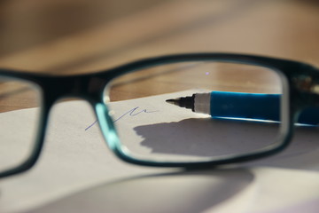 view through glasses on a pen with handwriting