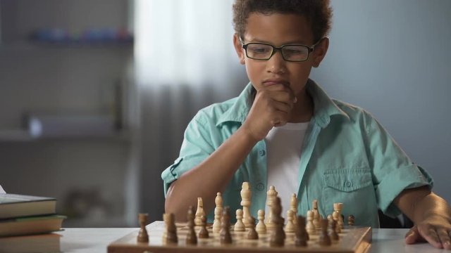 Smart boy playing chess carefully thinking through each move, logical game