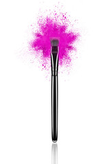 Pink make up brush with powder splash close-up, isolated on white background
