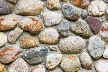 The wall of the building from the sea of boulders of different colors, round shape.