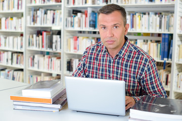 Serious man working in library