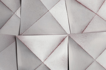 White paper sheets folded in geometric shapes