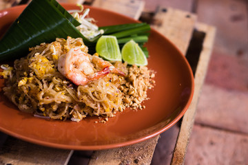 Traditional thai cuisine, Pad Thai, made with shrimp, noodles, egg, tamarind water and spices with lime and sprouts as side.