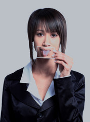 Girl holding a card with photo her tongue in front of her mouth