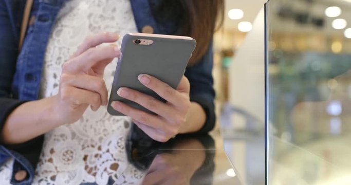 Woman looking at mobile phone in shopping mall