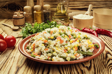 Colorful rice and vegetable salad,Bowl of pasta (orzo) or rice with vegetables,selective focus,Appetizing healthy rice with vegetables in plate on a wooden background,Delicious risotto with vegetables