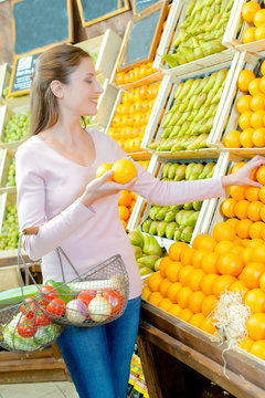 woman picking up oranges