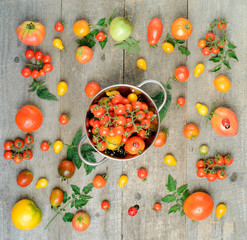 Fresh ripe tomatoes are in the box on wooden table. top view.