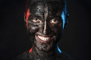 fun woman with black dirty smeared make up on black background