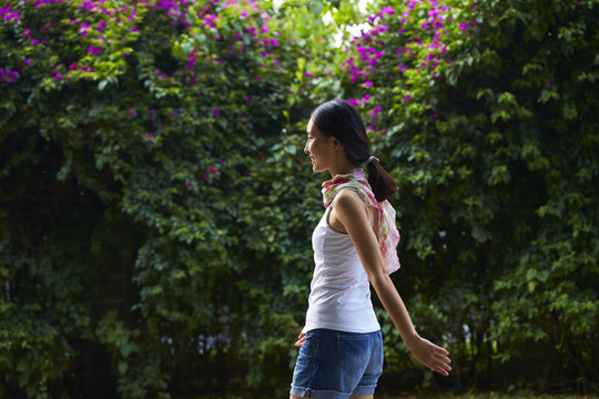 sideview of young asian woman walking outdoor